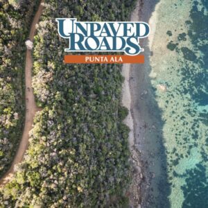 Vista aerea di un percorso gravel immerso nella vegetazione costiera di Punta Ala, con il mare cristallino sulla destra e una strada sterrata serpeggiante sulla sinistra, percorsa da ciclisti. Il logo di "Unpaved Roads Punta Ala" è posizionato nella parte superiore dell'immagine.